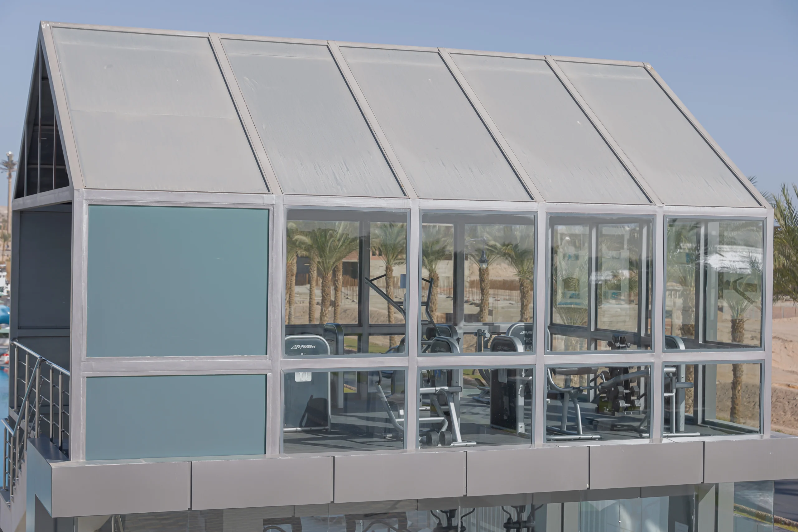 Glass-walled gym at Flow Spectrum Sahl Hasheesh with Life Fitness strength machines and views of palm trees